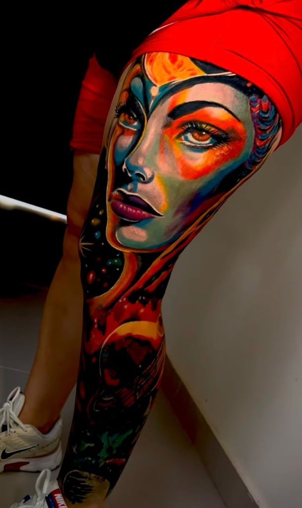 Retrato femenino a color tatuado en pierna con paleta vibrante
